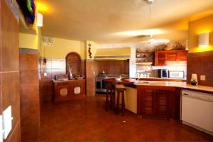 a large kitchen with wooden cabinets and a counter top at Villa Carolina Boutique Hotel ADULTS ONLY in Zihuatanejo
