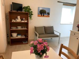een woonkamer met een tafel met een vaas met bloemen bij Masseria La Torre in Maglie