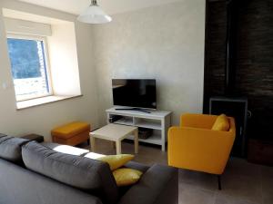 sala de estar con sofá y TV en Gite de Savker, en Campénéac