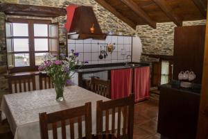 a kitchen with a table with a vase of flowers on it at Apartamentos Rurales El Foro in Andés