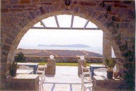 an archway in a building with tables and a view at Silver Rocks Hotel in Chrissi Akti