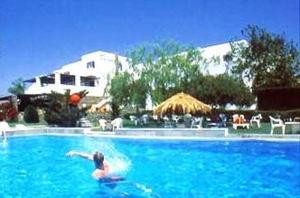 a person swimming in a large swimming pool at Silver Rocks Hotel in Chrissi Akti