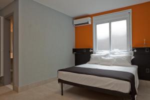 1 dormitorio con 1 cama grande y ventana en LOFT CATETE Baldô, en Río de Janeiro