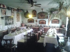 een eetkamer met tafels en stoelen en foto's aan de muren bij Gästezimmer in Lindenau in Leipzig