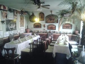 a dining room with tables and chairs and pictures on the walls at Gästezimmer in Lindenau in Leipzig