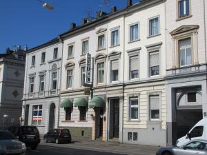 a large white building with green awnings on it at Hotel Hanseatic-garni in Wuppertal