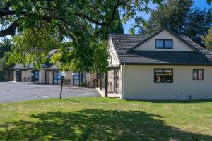 a house on a street with a tree at Ashleigh Court Motel in Blenheim