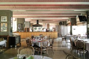a restaurant with tables and chairs and a kitchen at Al Bustan Hotel and Spa in Beit Meri