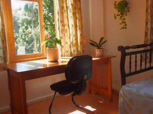 a desk with a chair in front of a window at Casa São Conrado in Rio de Janeiro
