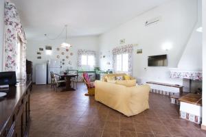 un soggiorno con divano giallo e una cucina di Villa Raimonda a Putifigari