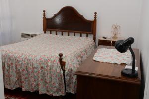 a bedroom with a bed and a lamp at Residencial o Bras in Alvaiázere
