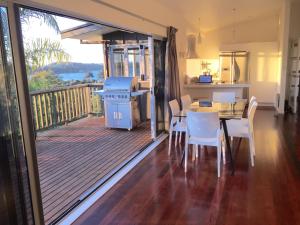 a kitchen and dining room with a balcony with a table and chairs at Waiheke Island Oneroa in Oneroa