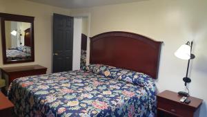 1 dormitorio con 1 cama con colcha de flores en Pleasant Hill Motel, en Middletown