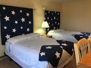 duas camas num quarto com estrelas na parede em The North Star Inn em Corinth