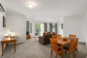 a living room with a table and a couch at Quest Bendigo in Bendigo