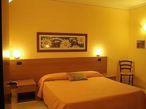 une chambre d'hôtel avec un lit et des murs jaunes dans l'établissement Il Piccolo Residence, à Acquaviva