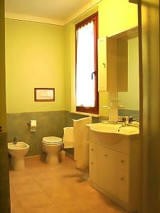 La salle de bains est pourvue d'un lavabo, de toilettes et d'un miroir. dans l'établissement Il Piccolo Residence, à Acquaviva