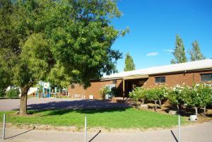 a brick building with a tree in front of it at Hilltop Resort in Swan Hill