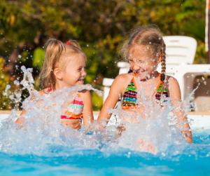 two little girls playing in the water in a pool at Hilltop Resort in Swan Hill