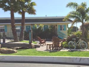 a bike parked in front of a house with palm trees at Beach Bungalow Inn and Suites in Morro Bay