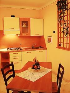 a kitchen with a table and a kitchen with a sink at Il Piccolo Residence in Acquaviva