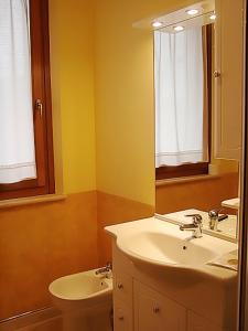 a bathroom with a sink and a toilet and a mirror at Il Piccolo Residence in Acquaviva