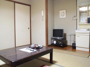 - un salon avec une table basse et une télévision dans l'établissement Kannawaso, à Beppu