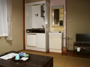 Il comprend un salon avec une cuisine équipée d'un évier et d'une table. dans l'établissement Kannawaso, à Beppu