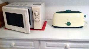 a microwave and a toaster oven on a kitchen counter at Location-Meublé in Issenheim