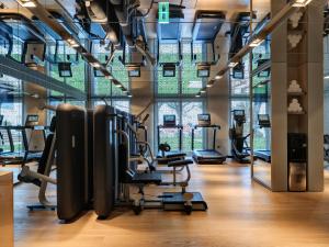 a gym with cardio equipment and a large window at Hotel Al Bustan in Beit Meri