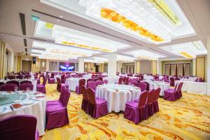 a banquet hall with white tables and purple chairs at JinLing Hotel SanFangXiang in Jiangyin