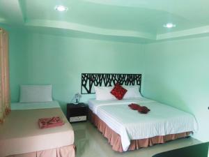 a bedroom with two beds with a stuffed animal on the bed at PhiPhi Coralbay in Phi Phi Islands +51 photos