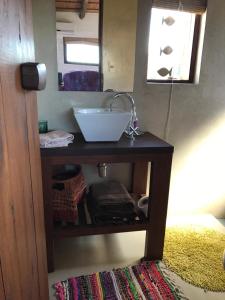 um toucador de casa de banho com um lavatório e um espelho. em Las Chasconas Cabañas Boutique em Punta Del Diablo