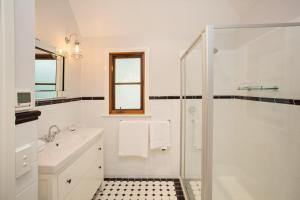 un bagno bianco con doccia e lavandino di Oak Tree Lodge a Rhyll