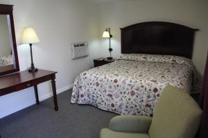a bedroom with a bed and a chair and a desk at Pleasant Hill Motel in Middletown