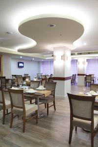 a dining room with wooden tables and chairs at Hotel Senbayrak City in Adana