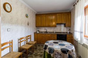 Una cocina con gabinetes de madera y una mesa y sillas. en Holiday Home Salva, en La Rinconada de la Sierra
