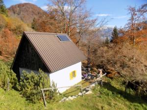 a small white house with a roof on a hill at Holiday Home Na planini in Tolmin