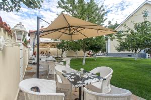 a patio with a table and chairs and an umbrella at Green Hill Guest House in Berkovitsa