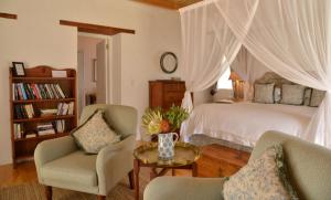 une chambre avec un lit, deux chaises et une table dans l'établissement De Hoop Collection Suites, à De Hoop Nature Reserve