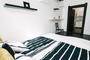 um quarto com uma cama com um cobertor listrado preto e branco em d.Five Stylish Apartment on Váci Street em Budapeste