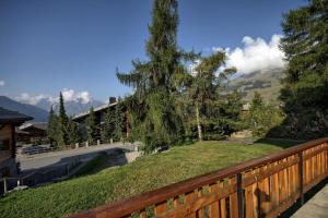 a wooden fence with a tree on top of a hill at Drelo 1 in Verbier