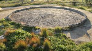 a circular patio in the middle of a garden at Antica Masseria Ficazzana - Tenuta in Marina di Pescoluse