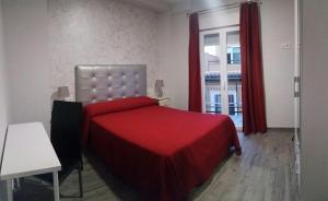 a bedroom with a red bed and a window at Cedran Granada Apartamento in Granada