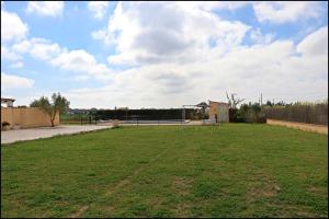 un gran campo de césped con un parque al fondo en Bungalow en complejo II, en Conil de la Frontera