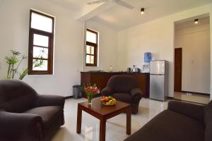 a living room with couches and a table and a refrigerator at Park Lane 88 Apartments in Negombo