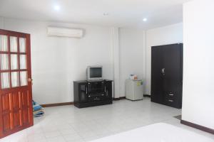 a living room with a tv and a black cabinet at Squid Resort in Haad Chao Samran