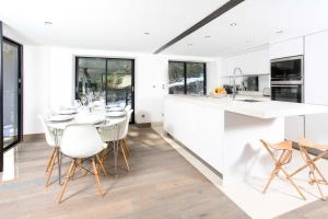 シャモニー・モンブランにあるChalet La Source - Chamonix All Yearの白いキャビネット、テーブルと椅子付きのキッチンが備わります。