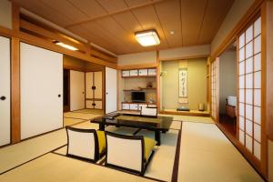 a dining room with a table and chairs in a room at Kyoto Ryokan Kinoe in Kyoto