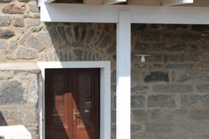 a stone house with a door and a stone wall at Il Dammuso di Tanit in Pantelleria